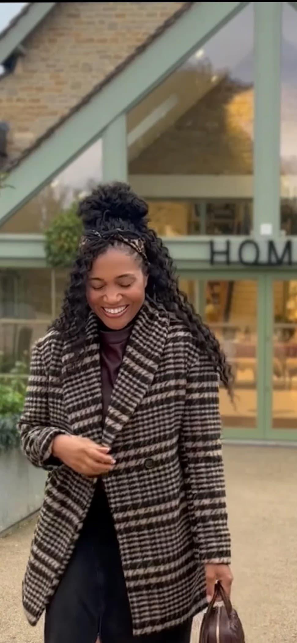 Kerry-Ann Stephens laughing as she steps out of the Daylesford farm shop in the Cotswolds