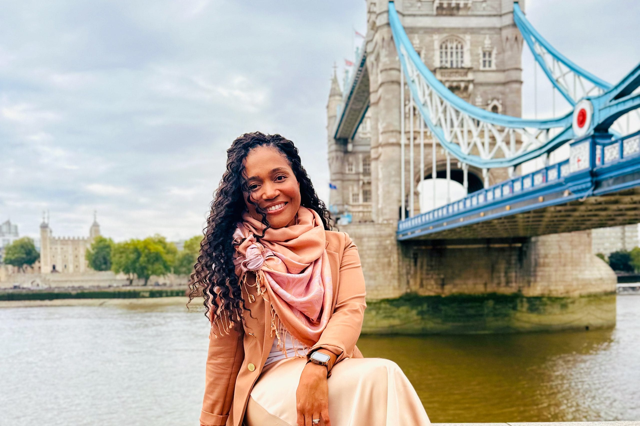Kerry-Ann Stephens on the river wall with Tower Bridge and the Tower of London behind her