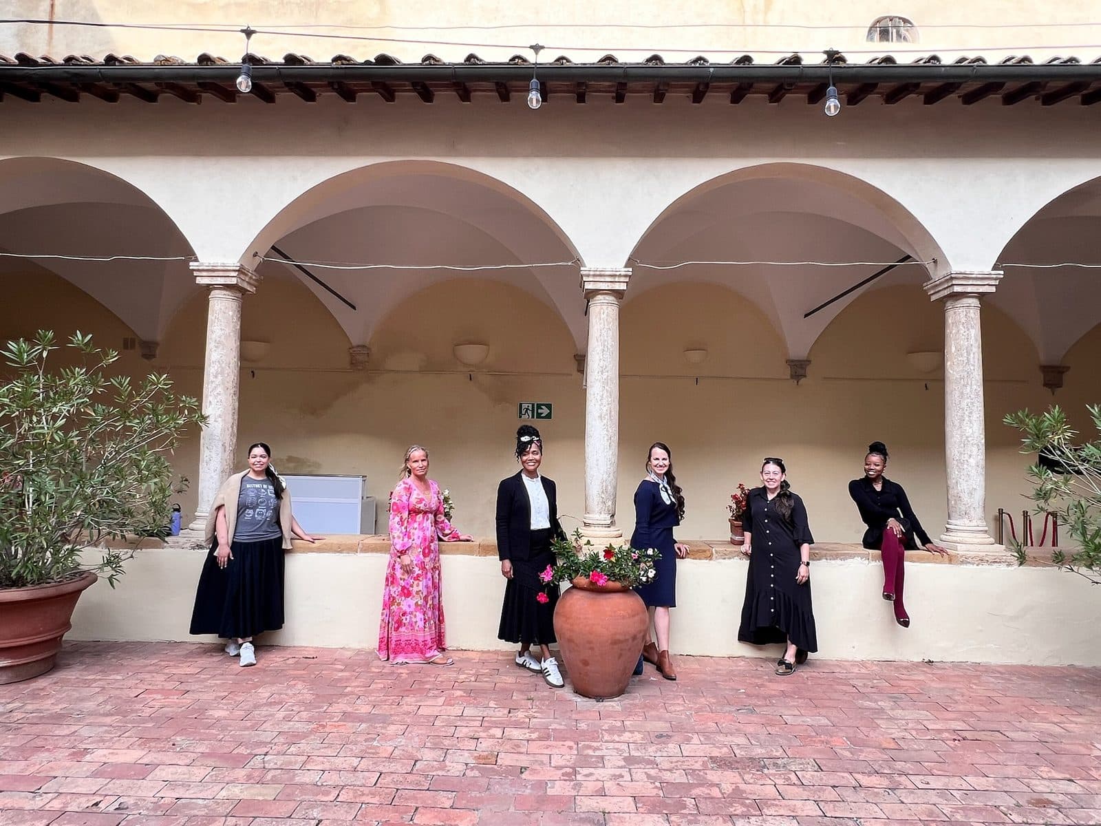 A group of women standing together in a Tuscan cloister