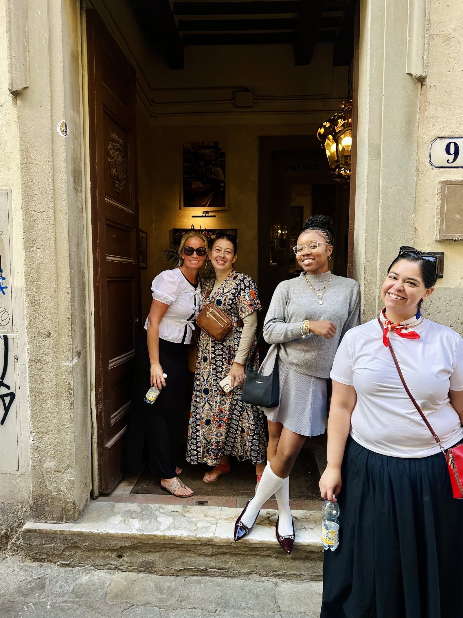 A group of women in a doorway on a Tuscan street, about to head out for the day