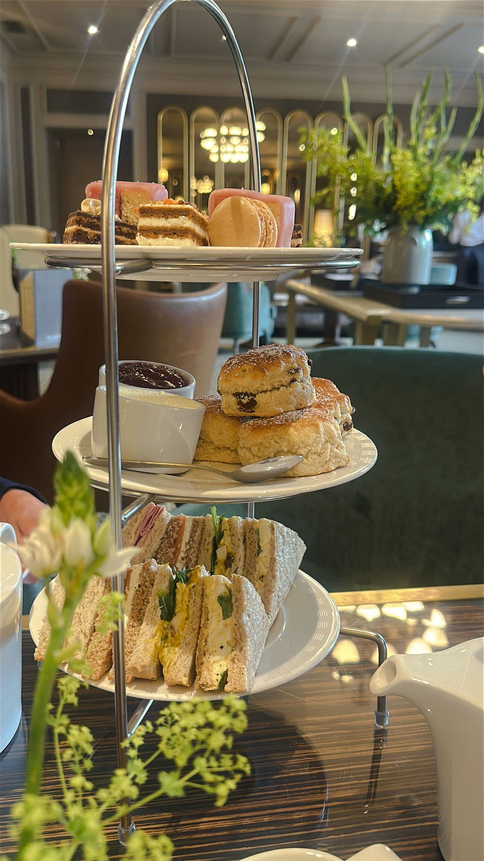 A tiered stand of sandwiches, scones and cakes set for afternoon tea