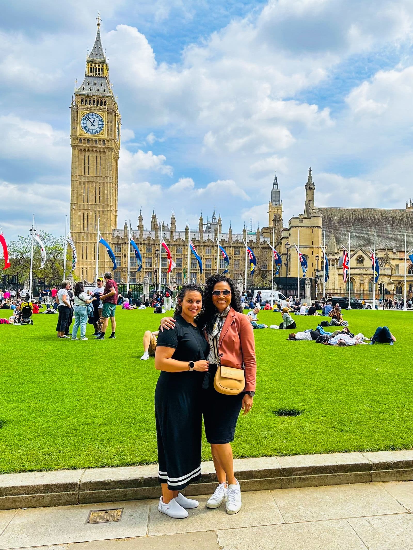 Two travelers on the grass of Parliament Square with Big Ben behind them