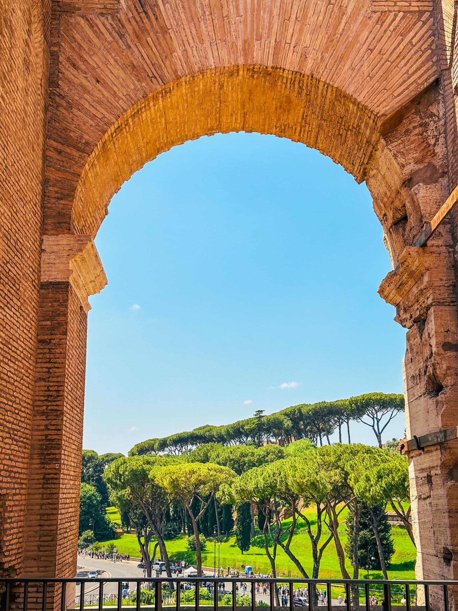 A stone arch framing a view over Rome's umbrella pines